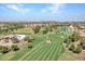 Expansive aerial view showcasing a meticulously maintained golf course and the surrounding neighborhood at 8541 W Rosemonte Dr, Peoria, AZ 85382