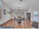 Bright dining room features wood floors, large windows with plantation shutters, and elegant chandelier at 8541 W Rosemonte Dr, Peoria, AZ 85382