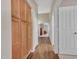 Hallway featuring a built-in linen closet, wood-look floors, and doorways leading to bedrooms and living areas at 8541 W Rosemonte Dr, Peoria, AZ 85382