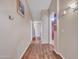 Well-lit hallway featuring wood flooring, neutral walls, arched doorway, and wall mounted lighting at 8541 W Rosemonte Dr, Peoria, AZ 85382