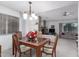 Elegant dining room with a glass-top table, chandelier, and seamless access to the living area at 980 Leisure World --, Mesa, AZ 85206