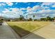 View of a lush green lawn with a building and a clock tower set against a bright sky at 980 Leisure World --, Mesa, AZ 85206