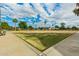 Well-maintained lawn with palm trees and benches, under a partly cloudy sky at 980 Leisure World --, Mesa, AZ 85206