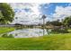 Scenic pond view with palm trees reflecting in the water under a partly cloudy sky at 980 Leisure World --, Mesa, AZ 85206