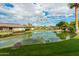 Picturesque view of a serene pond with lush green grass and palm trees reflected in the water at 980 Leisure World --, Mesa, AZ 85206