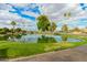 Scenic view of a tranquil pond surrounded by green lawns and palm trees under a bright sky at 980 Leisure World --, Mesa, AZ 85206