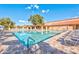 Community pool with lounge chairs, covered patio, and stairs leading to the pool, with sunny blue sky above at 980 Leisure World --, Mesa, AZ 85206