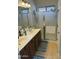 Bathroom with double sinks, framed mirrors, stylish vanity, and glass enclosed shower with tiled floor at 10 N Agua Fria Ln, Casa Grande, AZ 85194