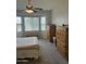 Comfortable bedroom featuring neutral decor, a ceiling fan, and plenty of natural light from the window at 10 N Agua Fria Ln, Casa Grande, AZ 85194