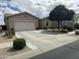 Charming single story home featuring a two car garage, desert landscaping, and well manicured bushes at 10 N Agua Fria Ln, Casa Grande, AZ 85194