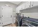 Laundry room with modern washer and dryer, cabinets, granite counters, and luxury vinyl floors at 10256 W Appaloosa Trl, Casa Grande, AZ 85194