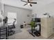 Spacious home office featuring dual desks, dual monitors, a ceiling fan, and wood-look tile floors at 10256 W Appaloosa Trl, Casa Grande, AZ 85194