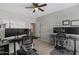 Spacious home office featuring dual desks, dual monitors, a ceiling fan, and wood-look tile floors at 10256 W Appaloosa Trl, Casa Grande, AZ 85194