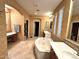 Luxurious bathroom featuring decorative tiled floors, dual vanities, and a large soaking tub at 1131 W Sierra Madre Ave, Gilbert, AZ 85233