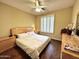 Bedroom featuring hardwood floors, a ceiling fan, window shutters, and neutral colored walls at 1131 W Sierra Madre Ave, Gilbert, AZ 85233