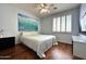 Comfortable bedroom with hardwood floors, ceiling fan, and serene wave artwork creating a relaxing atmosphere at 1131 W Sierra Madre Ave, Gilbert, AZ 85233