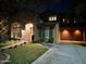 Inviting two-story home with stone accents, a well-lit driveway, and manicured lawn at twilight at 1131 W Sierra Madre Ave, Gilbert, AZ 85233