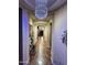 Elegant hallway featuring neutral paint, tile flooring, a stylish chandelier and decorative furnishings at 1131 W Sierra Madre Ave, Gilbert, AZ 85233