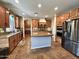 Spacious kitchen featuring an island, stainless steel appliances, tile floors, and wooden cabinets at 1131 W Sierra Madre Ave, Gilbert, AZ 85233