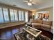 Bright living room with hardwood floors, a ceiling fan, a comfortable sofa, and plantation shutters at 1131 W Sierra Madre Ave, Gilbert, AZ 85233