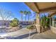 Backyard with desert landscaping, a covered patio, water feature, and palm trees at 1157 W Desert Lily Dr, San Tan Valley, AZ 85143