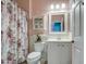 Cozy bathroom with a floral shower curtain, white vanity, and decorative wall cabinet at 1157 W Desert Lily Dr, San Tan Valley, AZ 85143