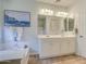 Bathroom showcasing double sinks, a bathtub, and elegant wall decor at 1157 W Desert Lily Dr, San Tan Valley, AZ 85143