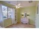 Light-filled bedroom with wood floors, a ceiling fan, and a pink dresser with an antique mirror at 1157 W Desert Lily Dr, San Tan Valley, AZ 85143