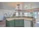 Open kitchen with a green cabinet and a decorative wrought iron light fixture at 1157 W Desert Lily Dr, San Tan Valley, AZ 85143