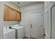 Laundry area with overhead cabinets and white washer/dryer units next to a door at 1157 W Desert Lily Dr, San Tan Valley, AZ 85143