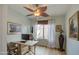 Bright home office with a modern desk, wood floors, and natural light from the window at 1157 W Desert Lily Dr, San Tan Valley, AZ 85143