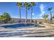 Beautiful pool with a waterfall feature and lush palm trees creating a serene outdoor oasis at 1157 W Desert Lily Dr, San Tan Valley, AZ 85143