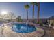 Inviting pool area featuring palm trees and a tranquil waterfall, perfect for relaxation and outdoor enjoyment at 1157 W Desert Lily Dr, San Tan Valley, AZ 85143