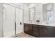 Bathroom with dual sinks, quartz countertops, dark wood cabinets, and a glass-enclosed shower at 12660 E Pivot Peak --, Gold Canyon, AZ 85118