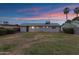 Backyard view showcasing the flat yard of this single-story home with minimal landscaping and neighboring palm trees at 1324 W 15Th St, Tempe, AZ 85281