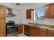 Kitchen with wood cabinets, stainless steel oven, and silver range hood at 1324 W 15Th St, Tempe, AZ 85281