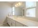 Bright bathroom featuring a large mirror, modern fixtures, and vanity storage at 14266 N 2Nd Ave, Phoenix, AZ 85023