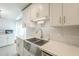 Bright kitchen features a stainless steel farmhouse sink, tiled backsplash, and white cabinetry at 14266 N 2Nd Ave, Phoenix, AZ 85023