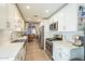 Bright and open kitchen layout with stainless steel appliances, white cabinets, and view into dining area at 14266 N 2Nd Ave, Phoenix, AZ 85023