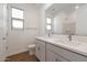 Modern bathroom featuring double sinks, wood look tile floors, and a window for natural light at 14790 W Tether Trl, Surprise, AZ 85387