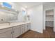 Elegant bathroom featuring double sinks, wood look tile floors, and a glass shower stall at 14790 W Tether Trl, Surprise, AZ 85387