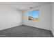 Clean bedroom featuring a window for natural light and neutral carpet flooring at 14790 W Tether Trl, Surprise, AZ 85387