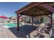 Covered gazebo with patio, pool view, complemented by red umbrellas, enhances outdoor living at 16492 N 181St Dr, Surprise, AZ 85388