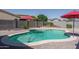 Inviting pool surrounded by desert landscaping and features a red umbrella for shade, perfect for relaxation at 16492 N 181St Dr, Surprise, AZ 85388