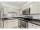 Well-lit kitchen featuring granite counters, stainless steel appliances, and crisp white cabinetry at 1702 W Tuckey Ln # 124, Phoenix, AZ 85015