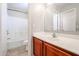 Bright bathroom with a single sink vanity, wood cabinets, and a shower-tub combination at 17474 W Acapulco Ln, Surprise, AZ 85388