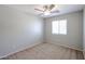 Bedroom with a window, carpeted floor, ceiling fan, and neutral colored walls at 17474 W Acapulco Ln, Surprise, AZ 85388