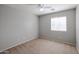 Neutral bedroom featuring a ceiling fan and a window allowing natural light at 17474 W Acapulco Ln, Surprise, AZ 85388