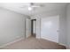 Neutral bedroom with carpet, closet with white doors, and view to a hallway at 17474 W Acapulco Ln, Surprise, AZ 85388