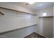 This large walk-in closet features built-in shelving and a small window for natural light at 17474 W Acapulco Ln, Surprise, AZ 85388